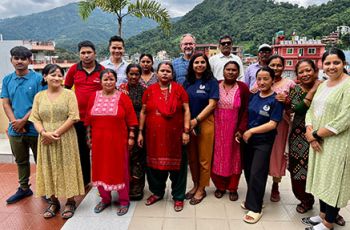 Brandon Kohrt standing among Nepalese community health workers
