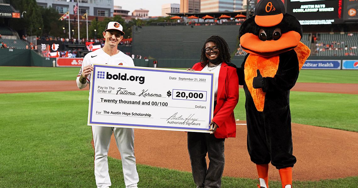 Orioles outfielder Austin Hays poses with Fatima Koroma as they both hold up a check