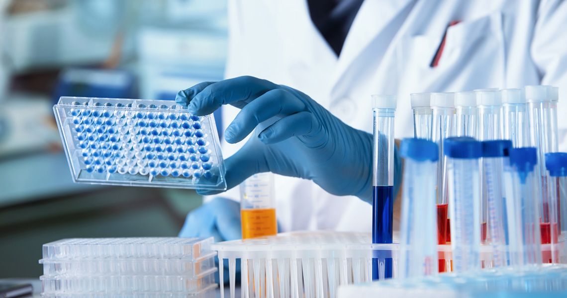 A scientist looking at test tube samples