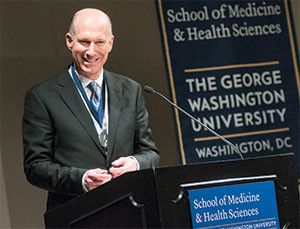 Dean Jeffrey Akman speaking at a podium