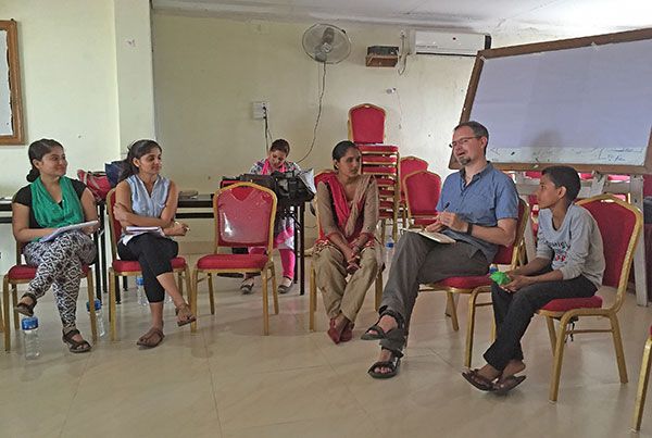 Brandon Kohrt sitting and speaking with community members in Nepal