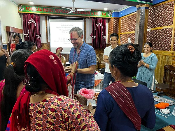 Brandon Kohrt receiving beads from Nepalese cohort